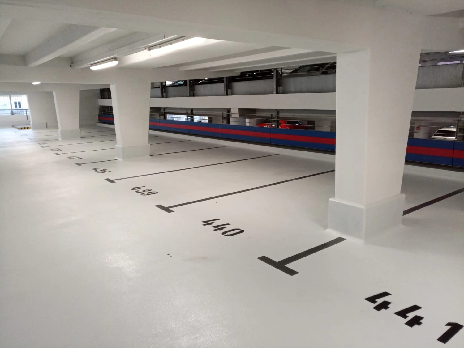 A&S Armbruster & Sieber GmbH - Experten im Bereich Bautenschutz und Bodenbeschichtungen - Leeres Parkhaus mit nummerierten Stellplätzen und weißen Säulen