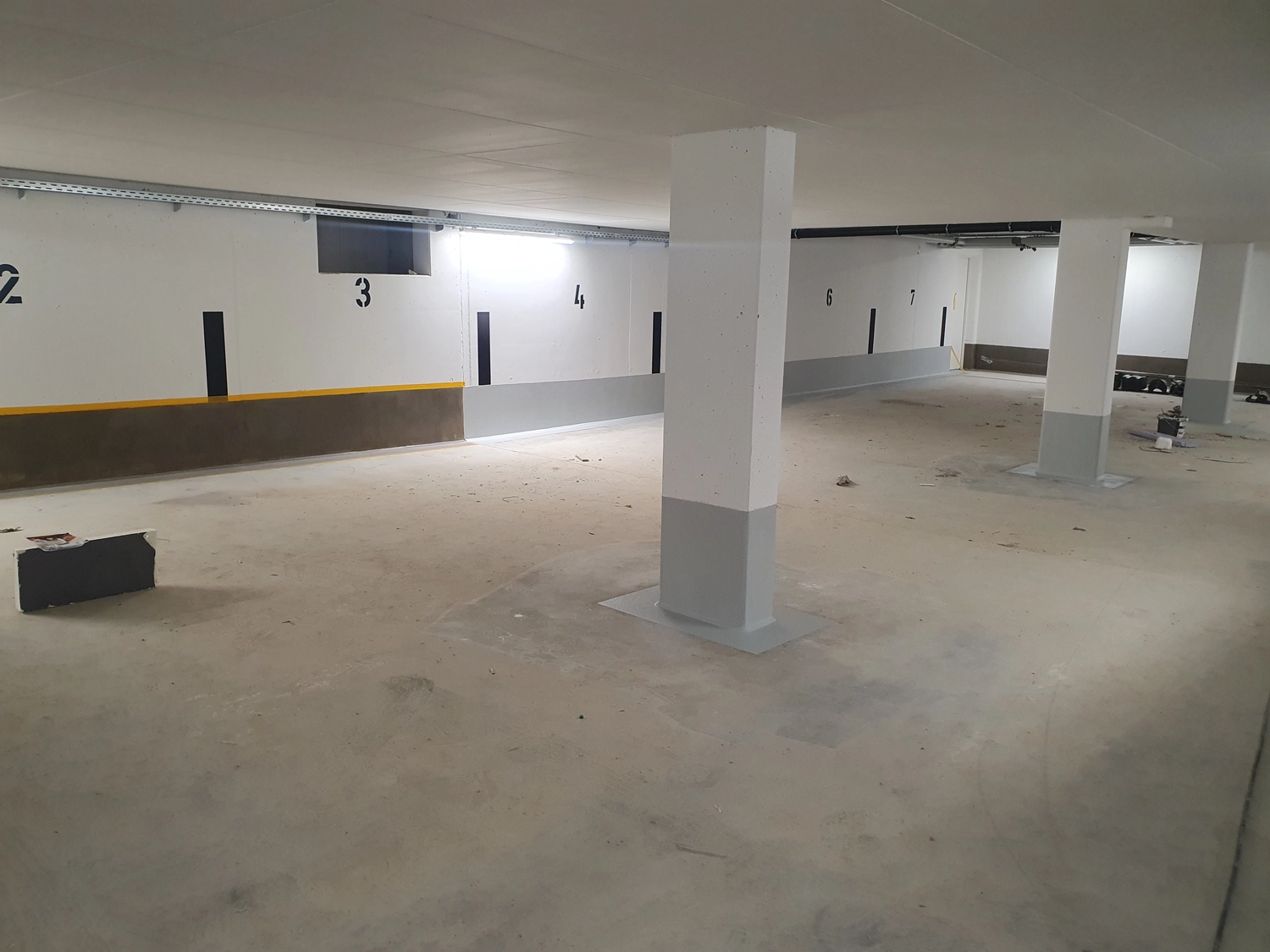 A&S Armbruster & Sieber GmbH - Experten im Bereich Bautenschutz und Bodenbeschichtungen - Leeres Parkhaus mit nummerierten Stellplätzen und Betonpfeilern