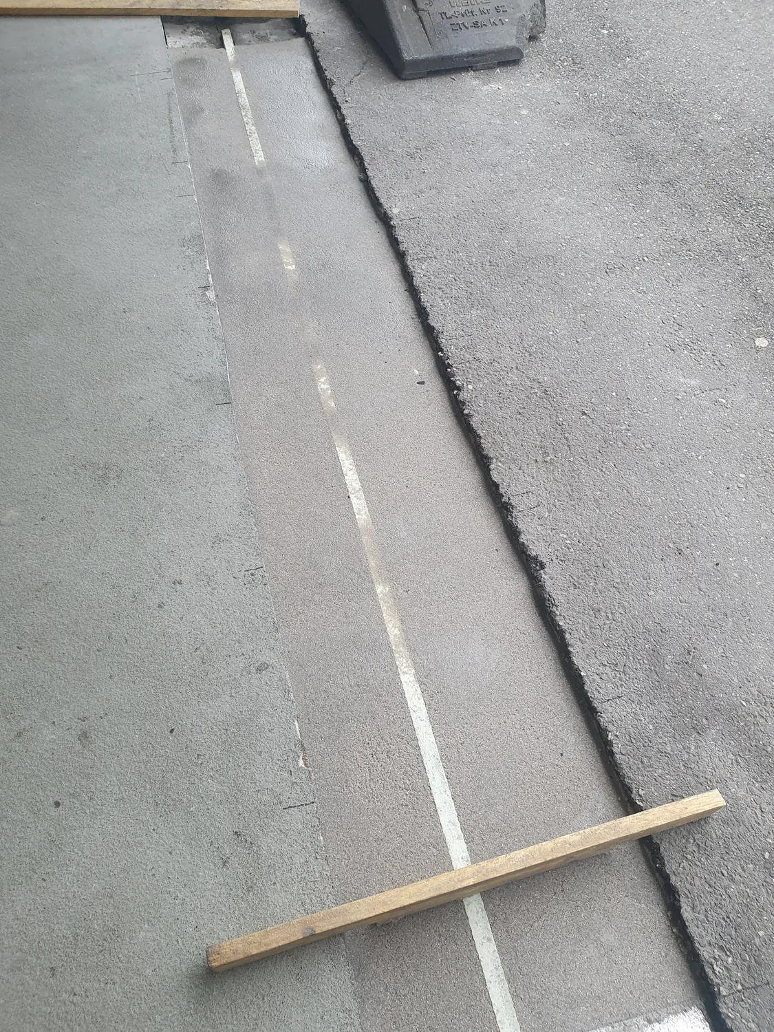 A&S Armbruster & Sieber GmbH - Experten im Bereich Bautenschutz und Bodenbeschichtungen - Betonoberfläche mit unterschiedlichen Strukturen und einem schräg darüber liegenden Holzstab